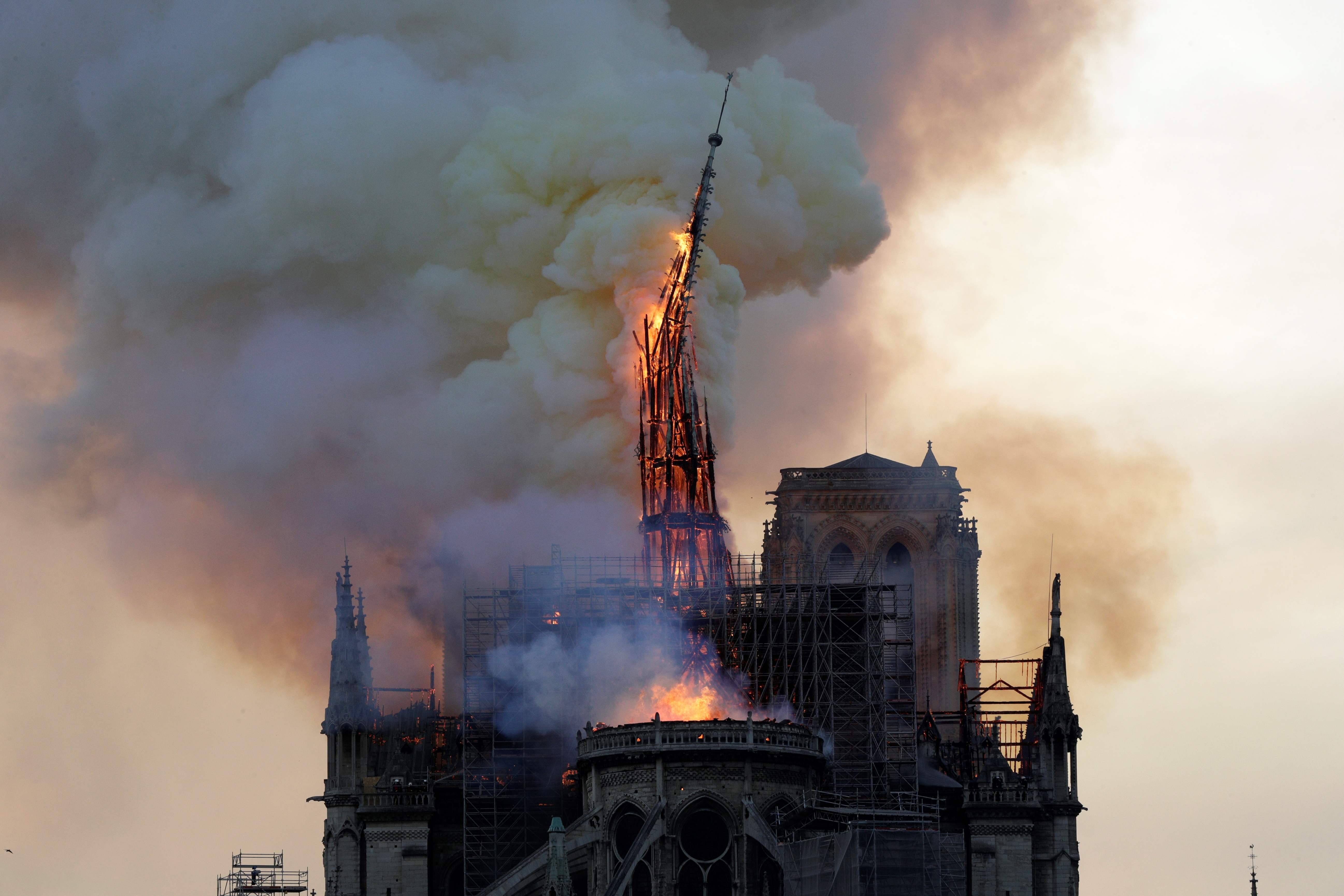 Momento en que se derrumba la aguja de la emblemática catedral de Notre-Dame, en París. (Foto Prensa Libre: AFP)