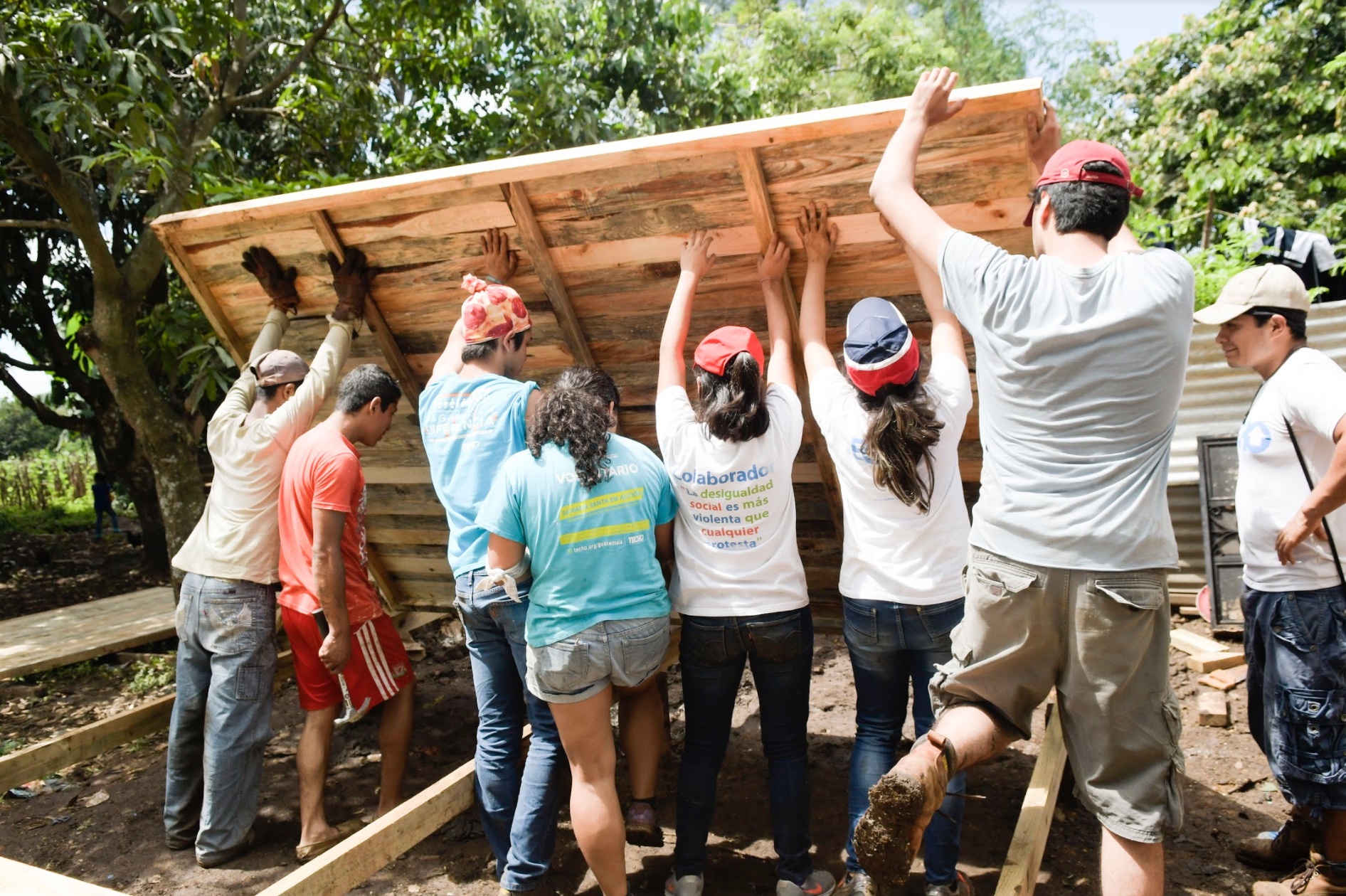 Voluntarios y familia beneficiada construyen una de las viviendas en comunidad beneficiada anteriormente. (Foto Prensa Libre: Cortesía Techo Guatemala). 