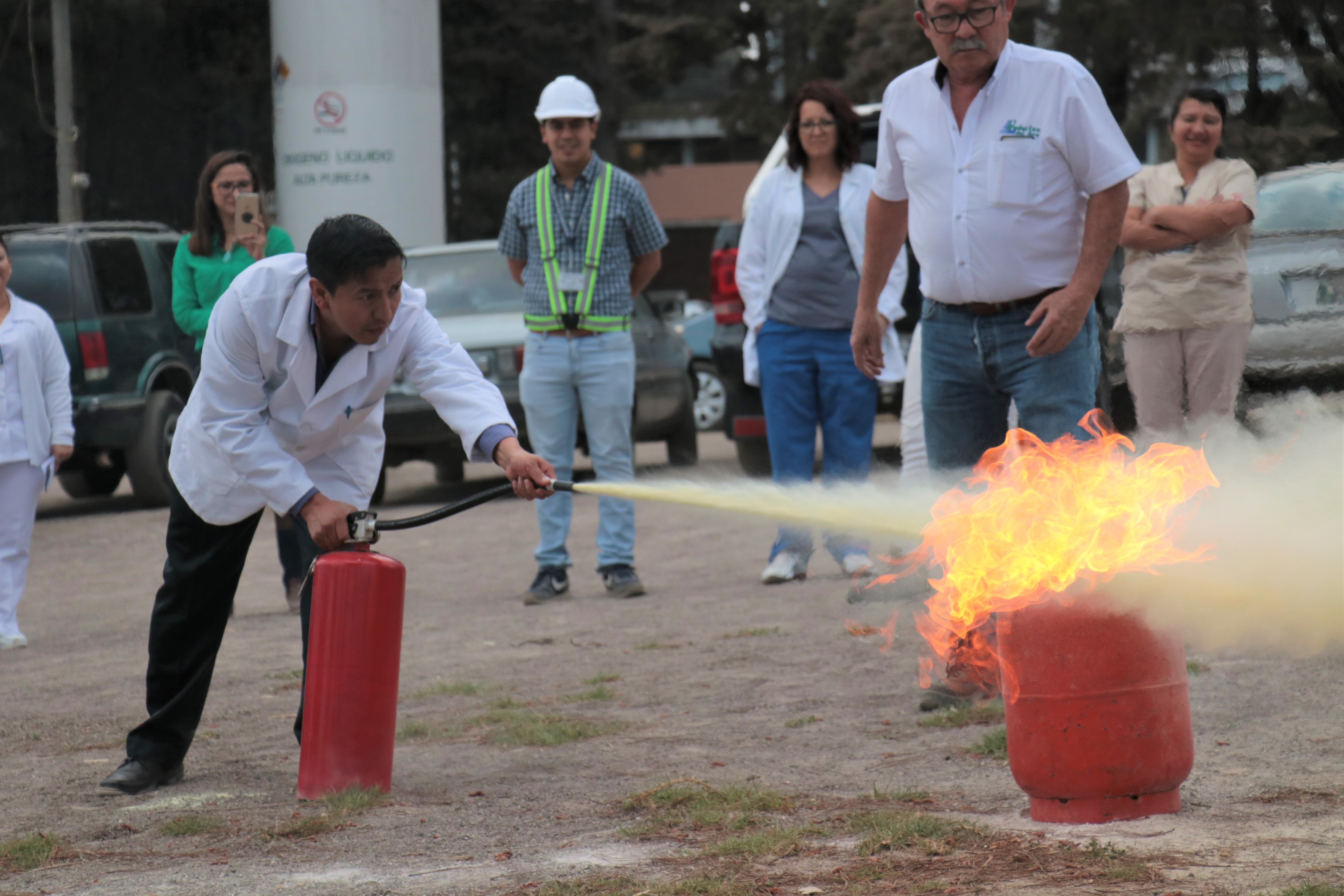 Los trabajores del HRO hicieron práctica con un cilindro de gas propano en llamas para mejorar el manejo de extintores. (Foto Prensa Libre: Raúl Juárez)