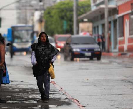 Algunas personas improvisaron sus trajes ante la sorpresiva lluvia. Foto Prensa Libre: Carlos Hernández