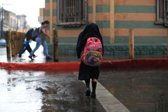 Jóvenes estudiantes se mojaron al salir de sus clases este medio día. Foto Prensa Libre: Carlos  Hernández