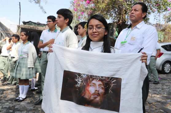 Jóvenes portaron imágenes de Jesús durante la realización del viacrucis en vivo. 