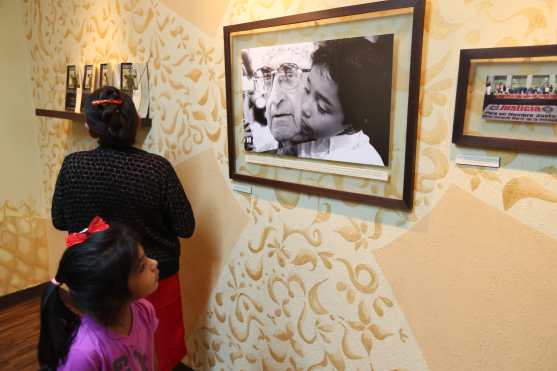 Una niña observa una de las fotografías en la exposición.