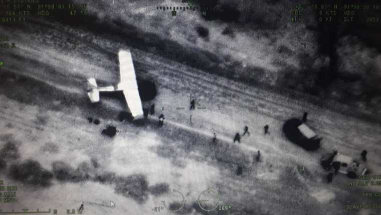 Esta fotografía fue captada desde una aeronave del Ejército y se evidencia cuando varias personas sacan cargamentos de la avioneta en el Manchón Guamuchal, Retalhuleu. (Foto Prensa Libre: Cortesía) 