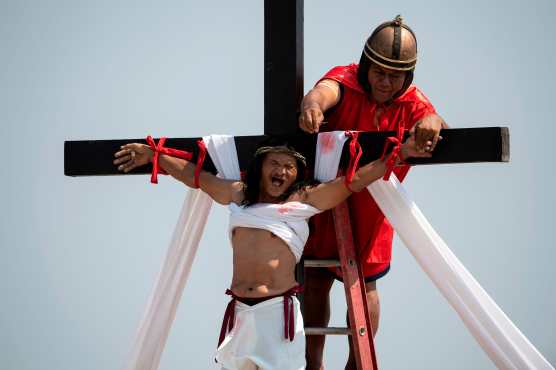 El devoto filipino cristiano Ruben Enaje, de 58 años, es clavado en una cruz durante una recreación de la Crucifixión de Cristo durante el Viernes Santo antes de la Pascua en la aldea de Cutud, cerca de San Fernando en Filipinas. Foto Prensa Libre: AFP
