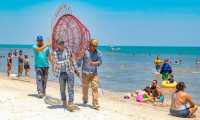 Personal de la comuna traslada una estructura metálica en forma de pez para instalarla como recolector de desechos de plástico en la playa Punta de Palma, Puerto Barrios, Izabal. (Foto Prensa Libre: Dony Stewart)