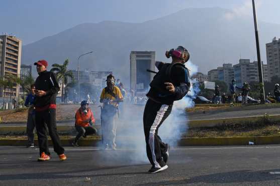 Desde tempranas horas de este 30 de abril las personas salieron a enfrentarse a las fuerzas de seguridad en Venezuela. Foto Prensa Libre: AFP 
