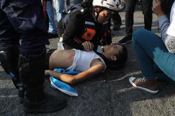 Un herido es atendido durante una protesta en apoyo al presidente de la Asamblea Nacional, Juan Guaidó, este martes, en Caracas, Venezuela. Foto Prensa Libre: EFE 