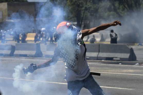 
Un manifestante de la oposición lanza un bote de gas lacrimógeno durante los enfrentamientos con soldados leales al presidente venezolano Nicolás Maduro después de que las tropas se unieran al líder opositor Juan Guaido. Foto Prensa Libre: AFP 