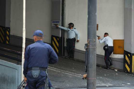Policías del Estado de Miranda y de Chacao se enfrentan con un civil armado que se encuentra al interior del Ministerio del Poder Popular para Transporte Terrestre durante una manifestación en apoyo al levantamiento de Juan Guaidó contra el gobierno de Nicolás Maduro. Foto Prensa Libre: EFE 