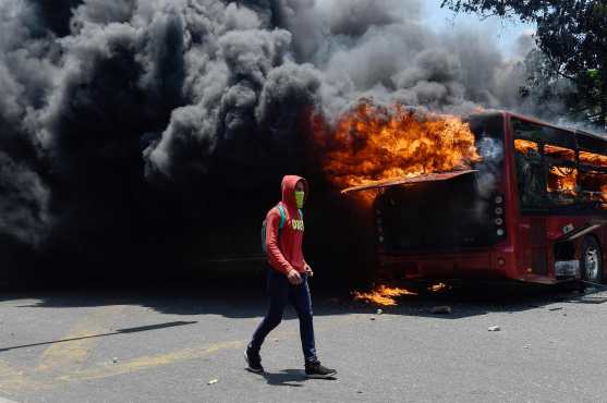 Varios vehículos fueron incendiados este día en las calles de Caracas. Foto Prensa Libre: AFP 
