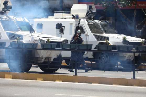 Vista de tanquetas y miembros de la Policía Nacional Bolivariana mientras tratan de bloquear el paso de la manifestación. Foto Prensa Libre: EFE 