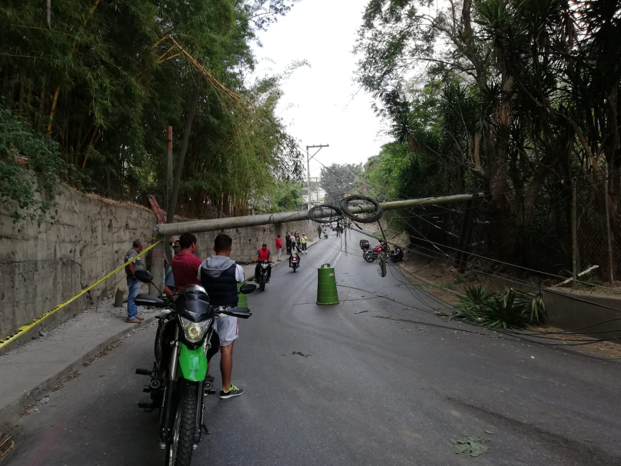 Vecinos de unas 10 colonias de la zona 18 quedaron aisladas por la caída de un poste de energía eléctrica en la carretera. (Foto Prensa Libre: La Red)