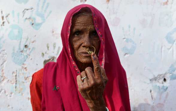 Una mujer india posa para una foto mientras muestra su dedo marcado con tinta después de emitir su voto durante las elecciones generales de la India en la aldea Kapoorawala, en Sanganer, en las afueras de Jaipur. Foto Prensa Libre: AFP 
