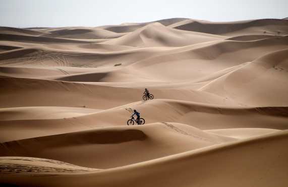 Los competidores viajan en bicicleta por las dunas de arena durante la Etapa 1 de la 14ª edición de la carrera de ciclismo de montaña Titan Desert 2019 alrededor de Merzouga en Marruecos. Foto Prensa Libre: AFP 