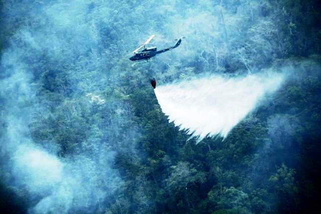 Un helicóptero apoya las labores para combatir los incendios forestales activos en Petén. (Foto Prensa Libre: Conred).