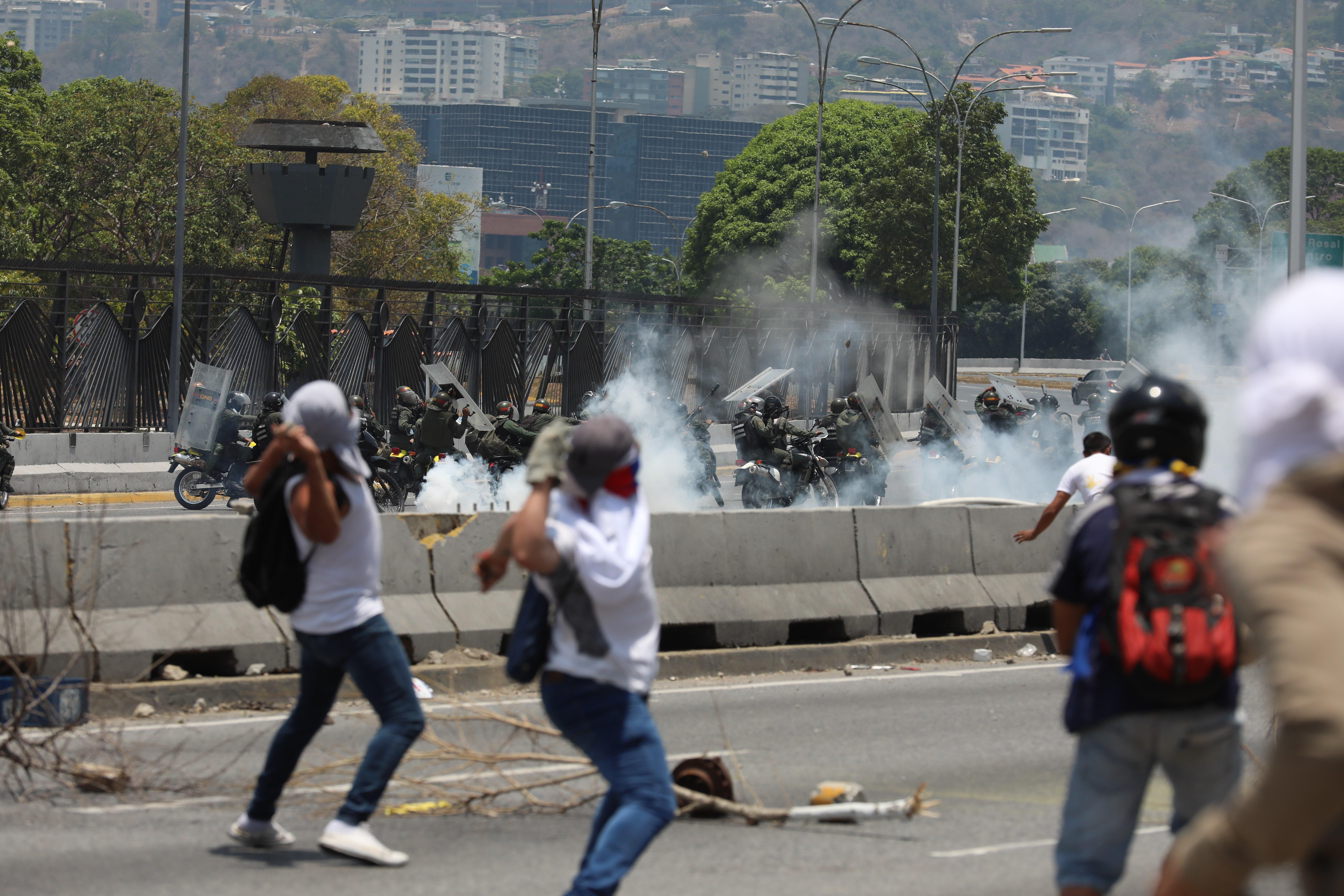 Manifestantes opositores se enfrentan con miembros de la Guardia Nacional Bolivariana en las calles de Caracas. (Foto Prensa Libre: EFE)