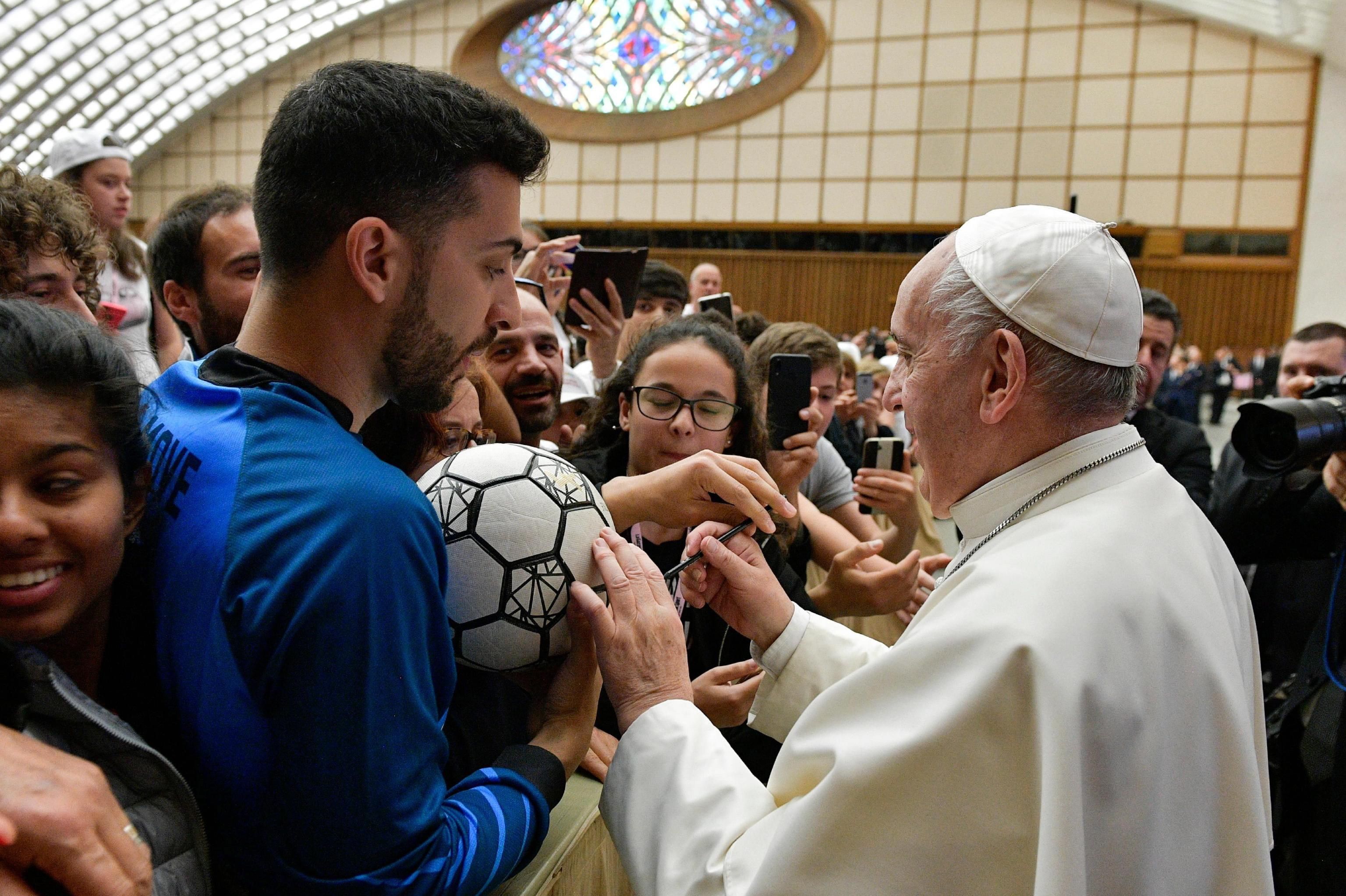 El papa Francisco (d) firma un balón durante el evento "Il Calcio che Amiamo" (lit. El fútbol que amamos), organizado por el periódico deportivo italiano "La Gazzetta dello Sport". (Foto Prensa Libre: EFE)