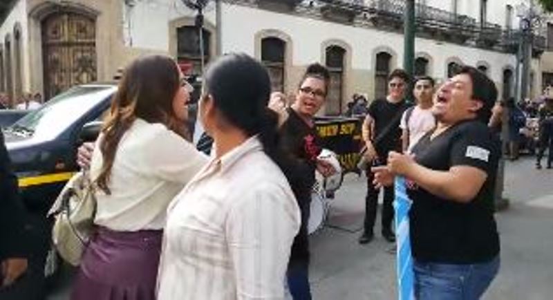 Diputada Patricia Sandoval (izq) saluda con ironía a un manifestante.