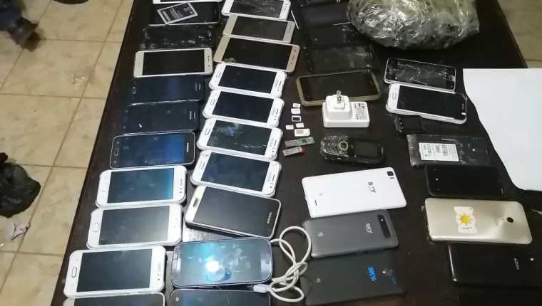Los teléfonos móviles localizados en la cárcel Pavón después del motín. (Foto Prensa Libre: PNC)