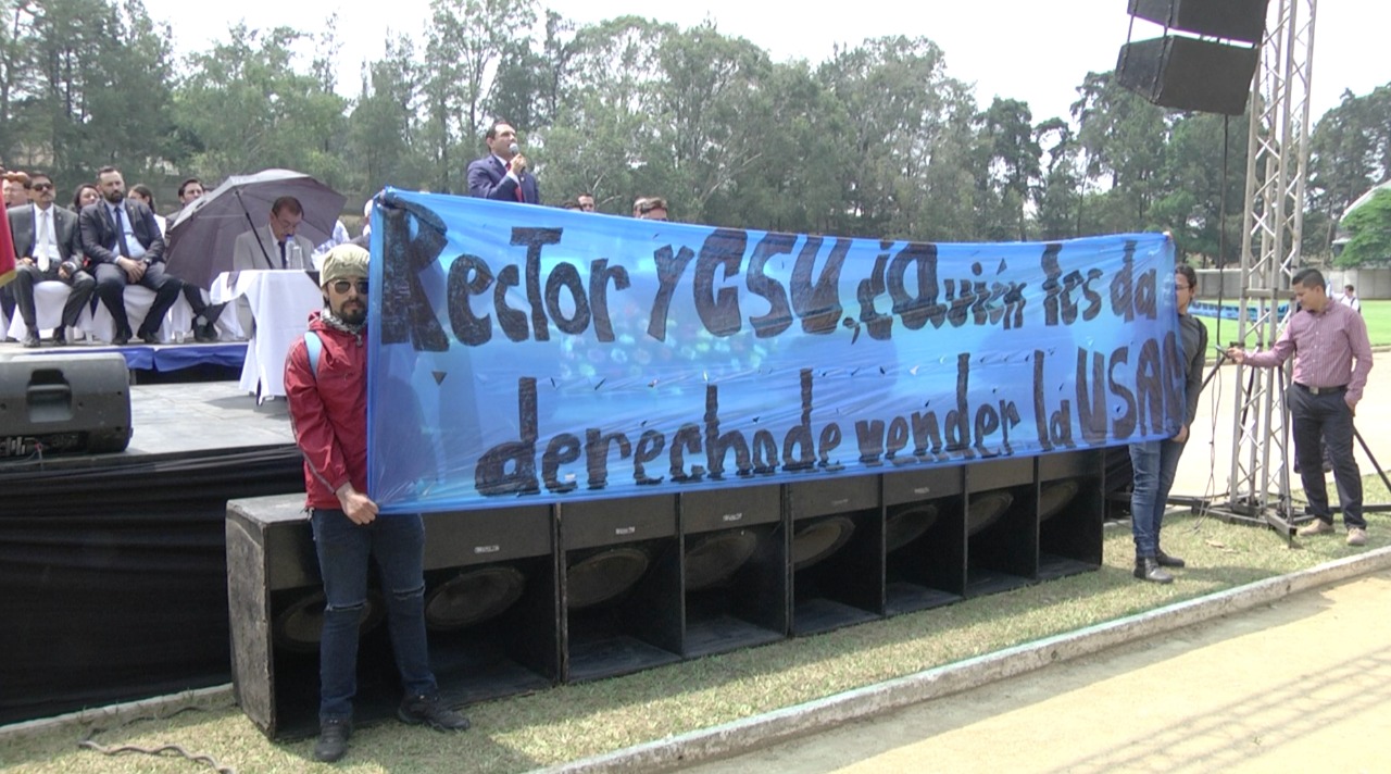 Sancarlistas mostraron una manta contra el rector Murphy Paiz y el Consejo Superior durante el acto de juramentación d ela misión de observación electoral.  (Foto Prensa Libre: Dulce Rivera)