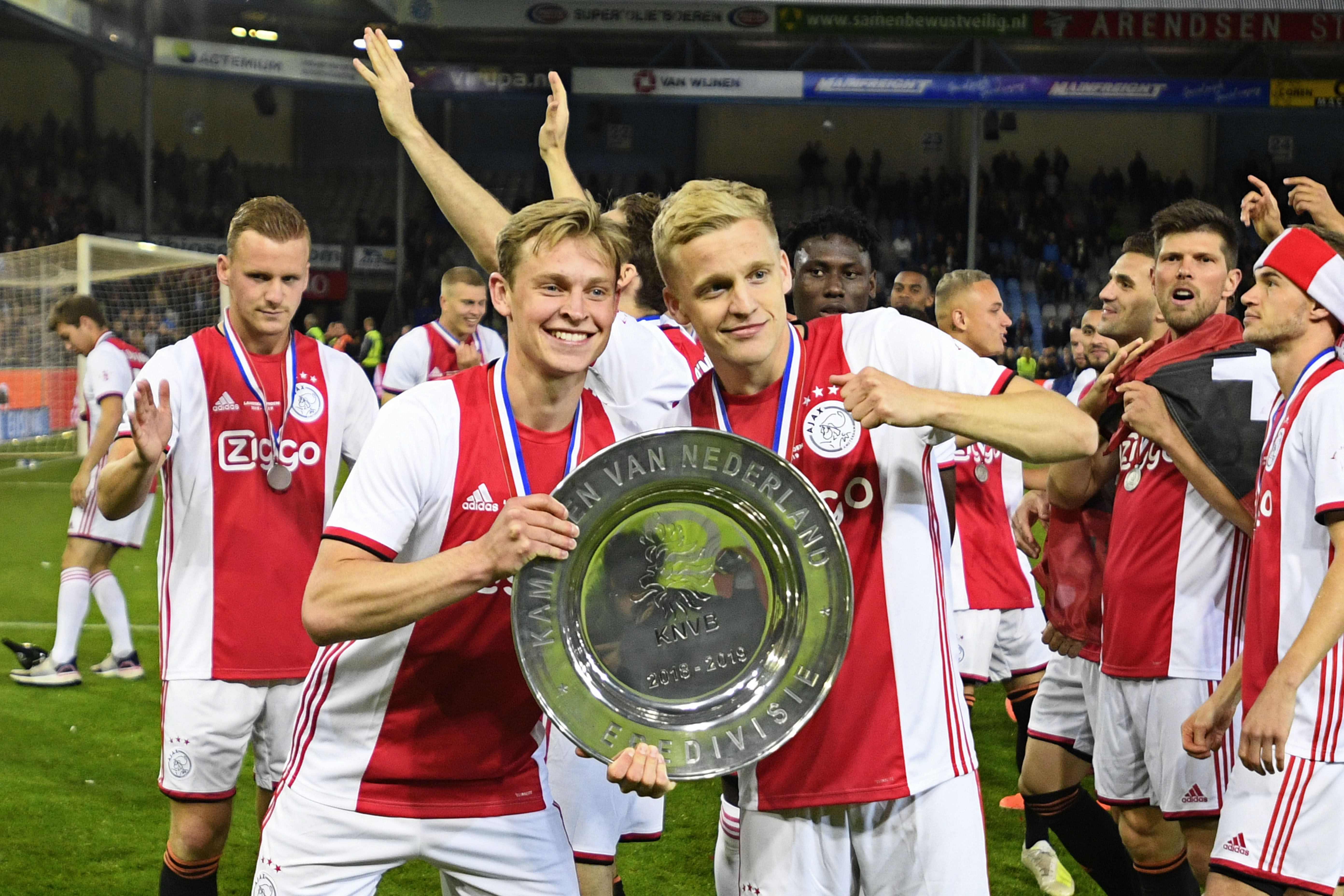 Frenkie de Jong (izquierda) celebra junto a Donny van de Beek la liga holandesa. (Foto Prensa Libre: AFP)