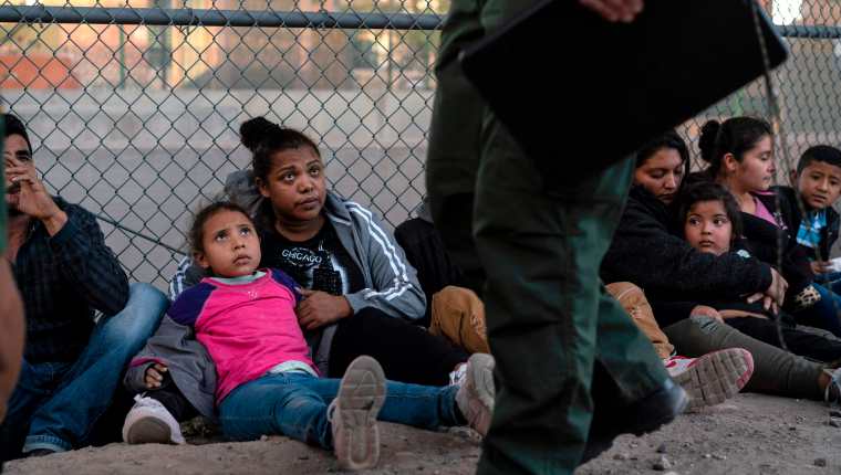 Migrantes centroamericanos esperan un vehículo en El Paso, Texas, que los lleve a un albergue y su posterior deportación. (Foto Prensa Libre:  AFP)