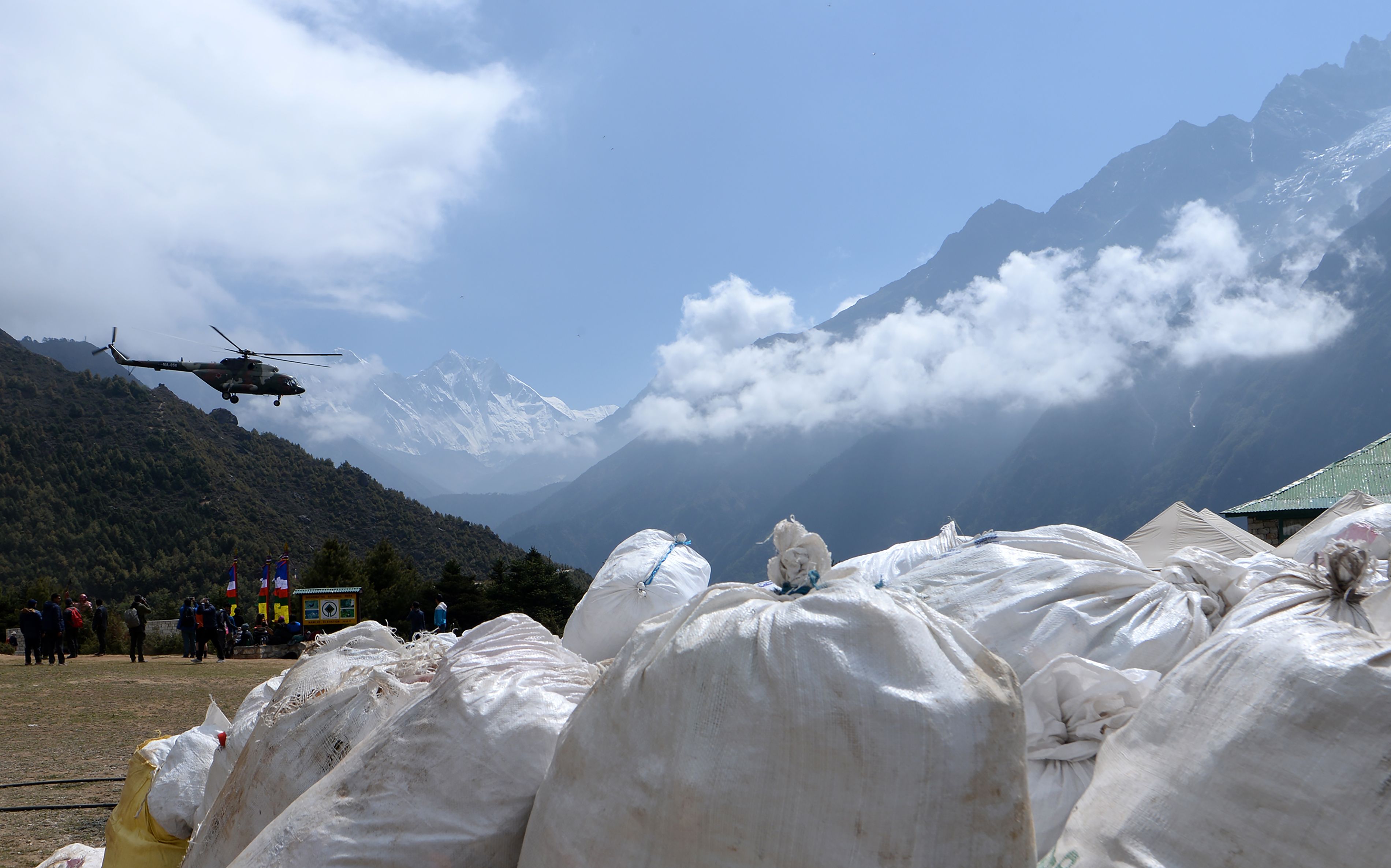 Un helicóptero del Ejército nepalí sobrevuela los desechos recolectados en el monte Everest. (Foto Prensa Libre: AFP)