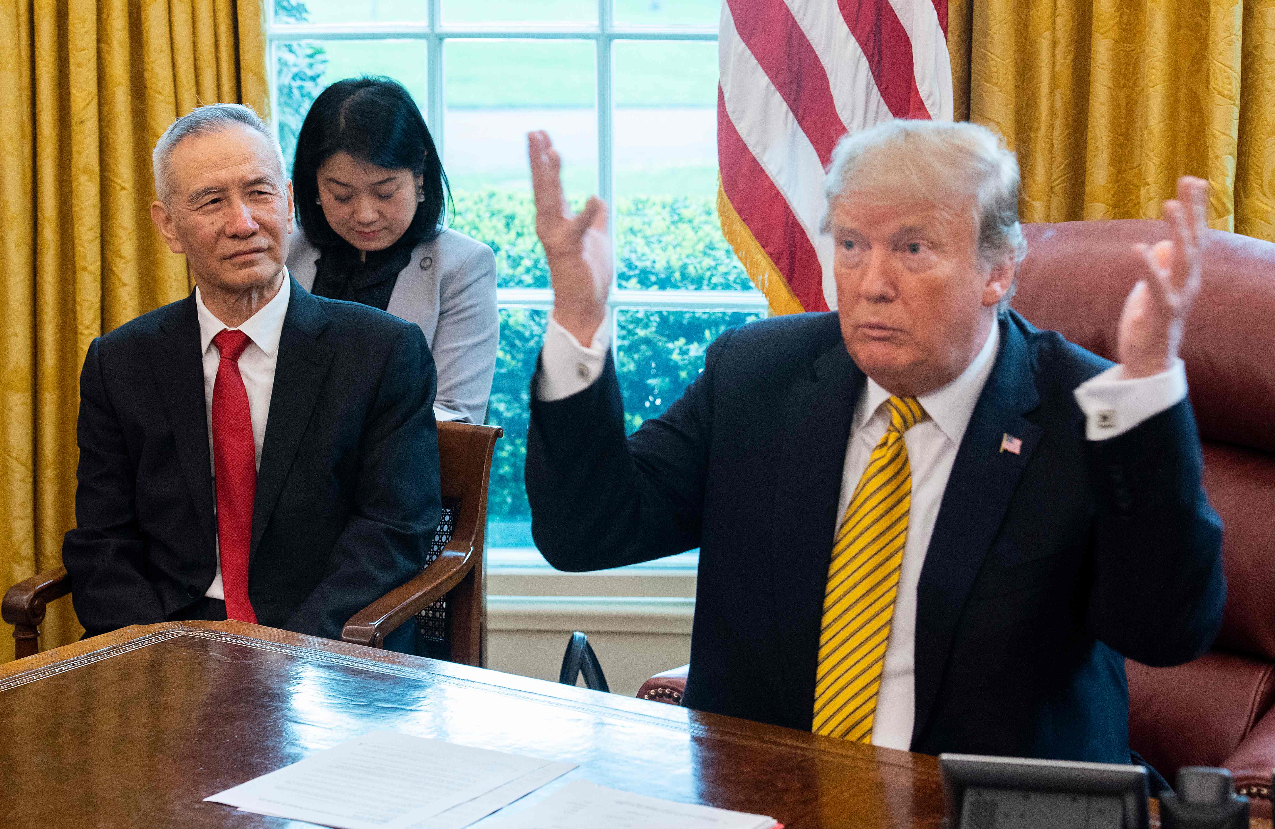 El vicepresidente de China, Liu He, junto a su par estadounidense, Donald Trump en una reunión del 4 de abril. (Foto Prensa Libre: AFP)