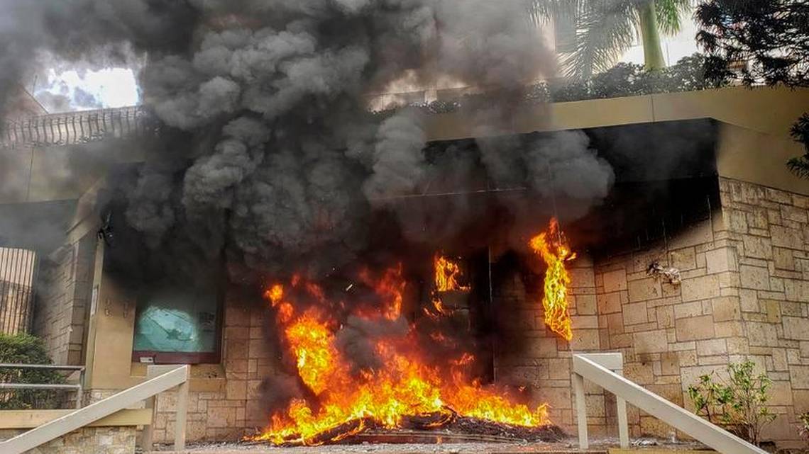 El incendio provocado por los manifestantes en la entrada a la embajada de Estados Unidos en Honduras. (Foto Prensa Libre: AFP).