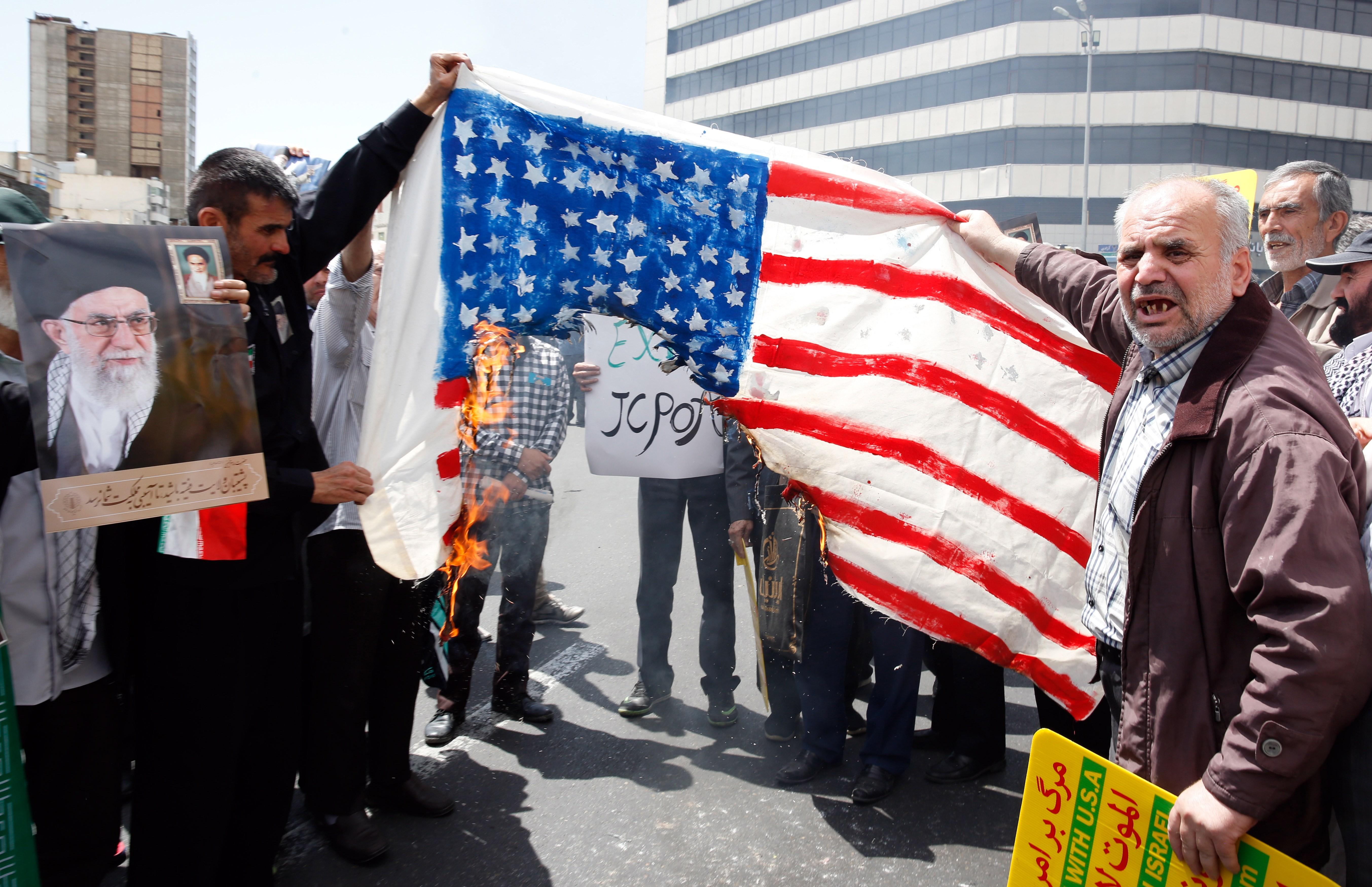 Manifestantes iraníes queman banderas estadounidenses durante una protesta contra la administración Trump. (Foto Prensa Libre: EFE)