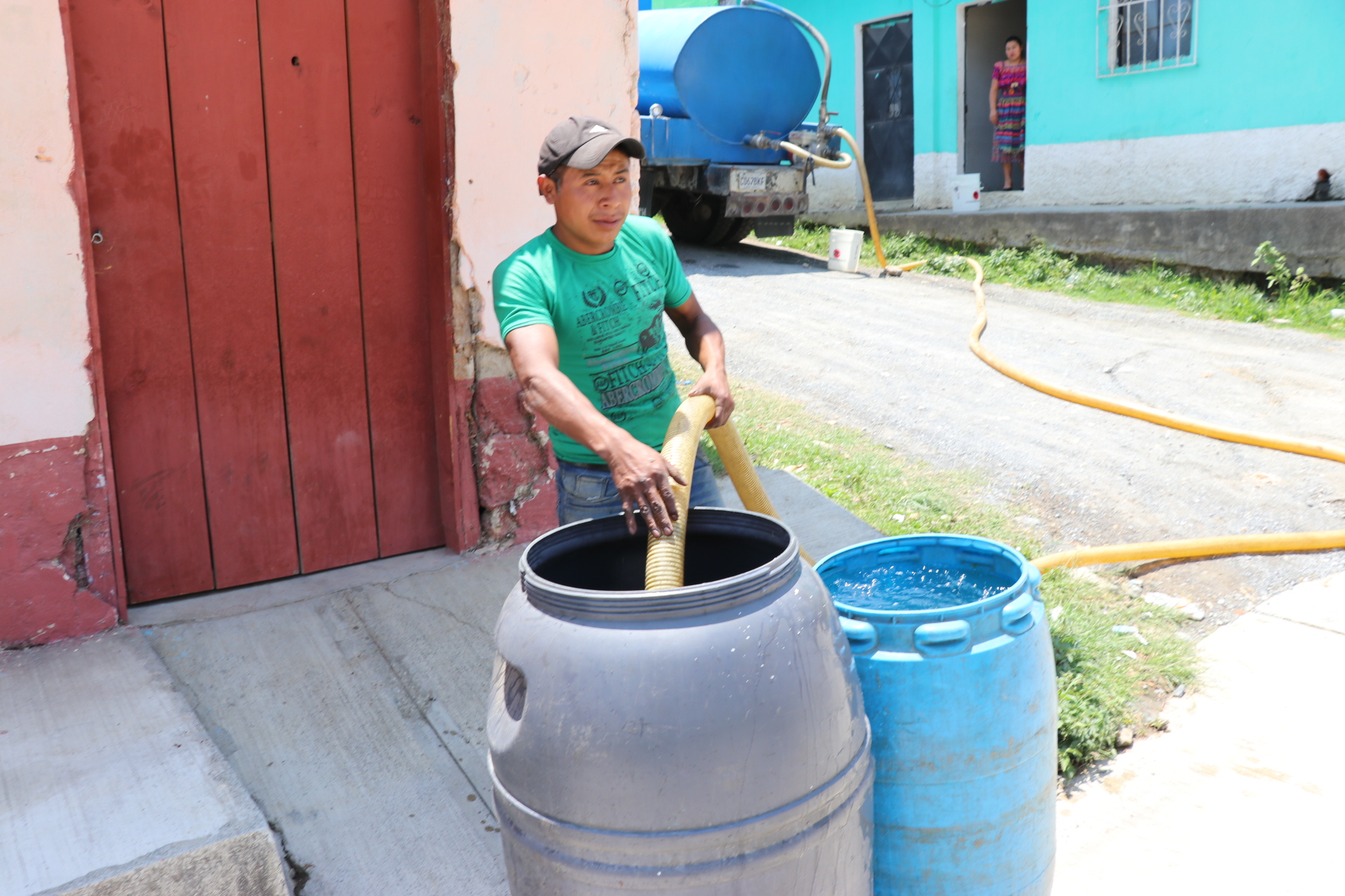 El encargado de un camión cisterna llena dos toneles de agua para un vecino de Uspantán, Quiché. (Foto Prensa Libre: Héctor Cordero).