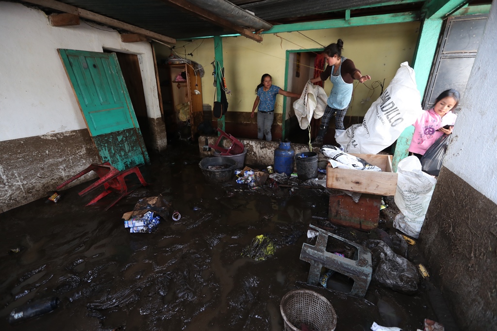 Familiares de Vilma López rescatan algunas pertenencias de la damnificada. (Foto Prensa Libre: Mynor Toc)