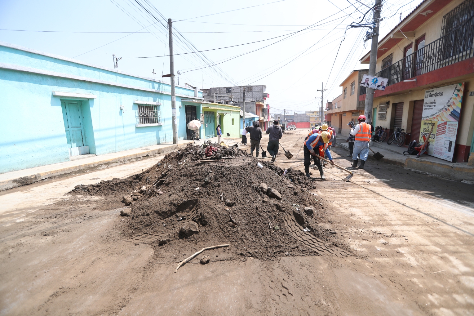 1.	Vecinos y empleados municipales se unieron para recolectar el lodo y la tierra que quedó en las calles por las inundaciones. (Foto Prensa Libre:  : María José Longo)