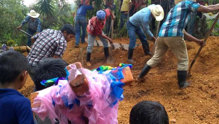 Vecinos y amigos de la familia ayudan a sepultar el féretro. La lluvia incrementó durante la sepultura. (Foto Prensa Libre: Mario Morales)

