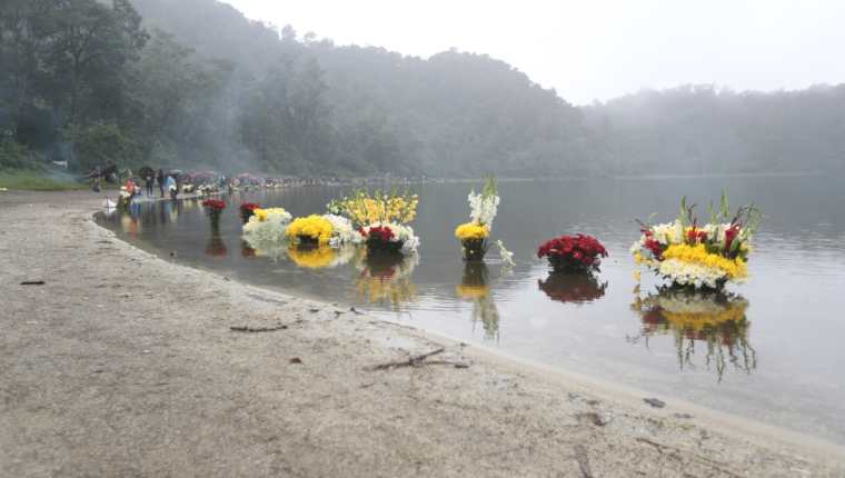 Alrededor de la laguna los visitantes colocaron flores como ofrenda por sus peticiones. (Foto Prensa Libre: María Longo) 