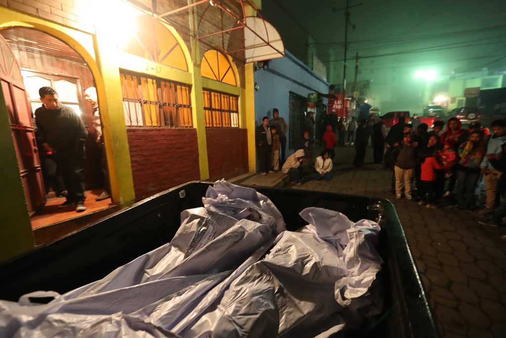 Curiosos, familiares y vecinos de la colonia San Antonio, zona 7, observan los cadáveres que serán trasladados al Inacif. (Foto Prensa Libre: Mynor Toc)