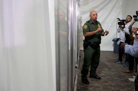 El portavoz de la Patrulla Fronteriza, Ramiro Cordero, habla dentro del área de la ducha del nuevo centro de detención temporal para migrantes. Foto Prensa Libre: AFP 