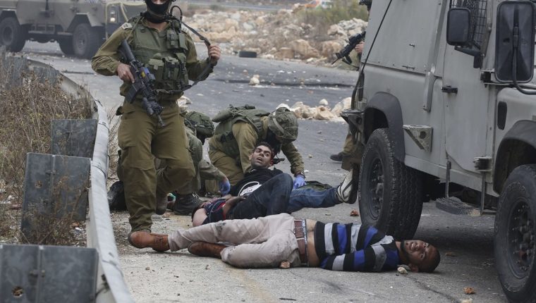 Soldados israelíes detienen a manifestantes palestinos durante la escalada de violencia que ha tenido lugar en Israel. (Foto Prensa Libre: AFP). 