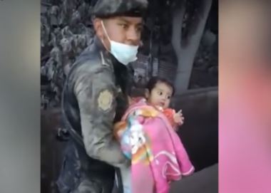 Imagen icónica del rescate de Esmeralda por un agente después de la violenta erupción del Volcán de Fuego. (Foto: Hemeroteca PL)