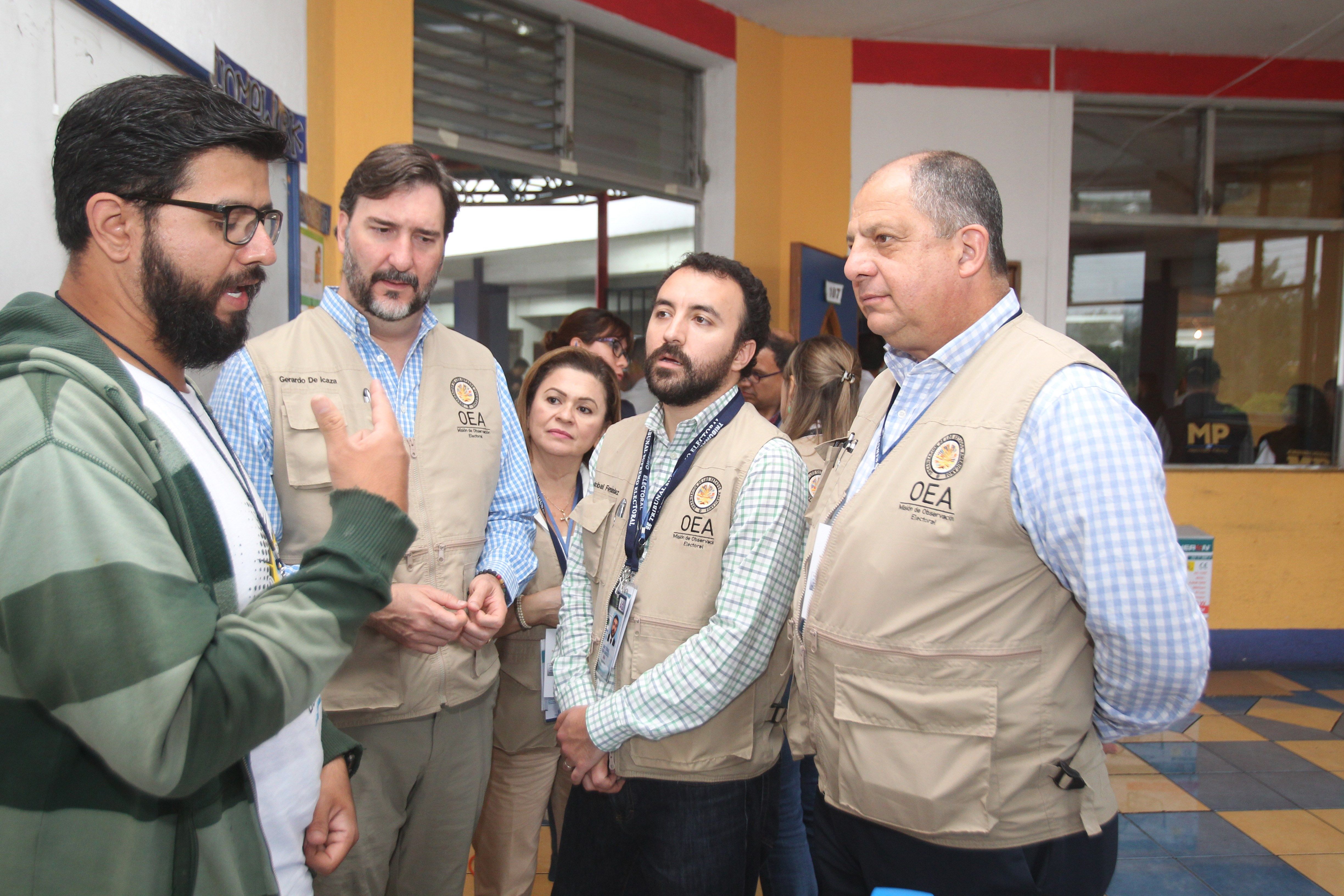 El jefe de la misión electoral de la Organización de los Estados Americanos (OEA), el expresidente costarricense Luis Guillermo Solís (d), en una visita a un colegio electoral. (Foto Prensa Libre: EFE)