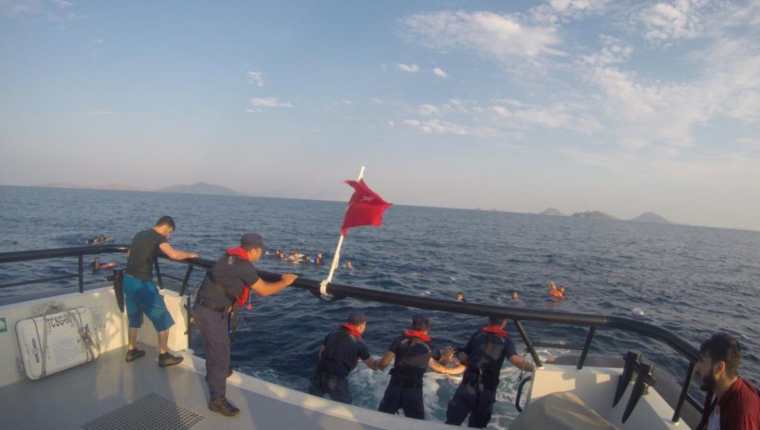 Un barco turco rescata a migrantes quienes viajaban en una embarcación que se hundió en el mar Egeo. (Foto Prensa Libre: EFE)