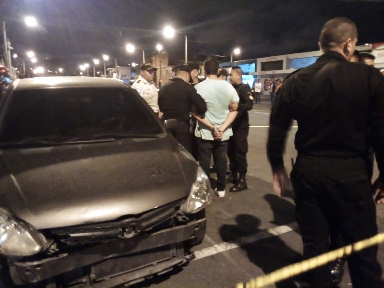 La Policía custodia a uno de los capturados. (Foto Prensa Libre: PNC).