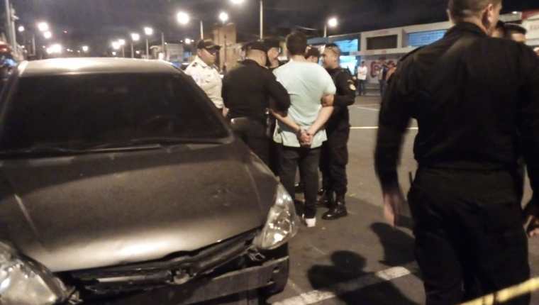 La Policía custodia a uno de los capturados. (Foto Prensa Libre: PNC).