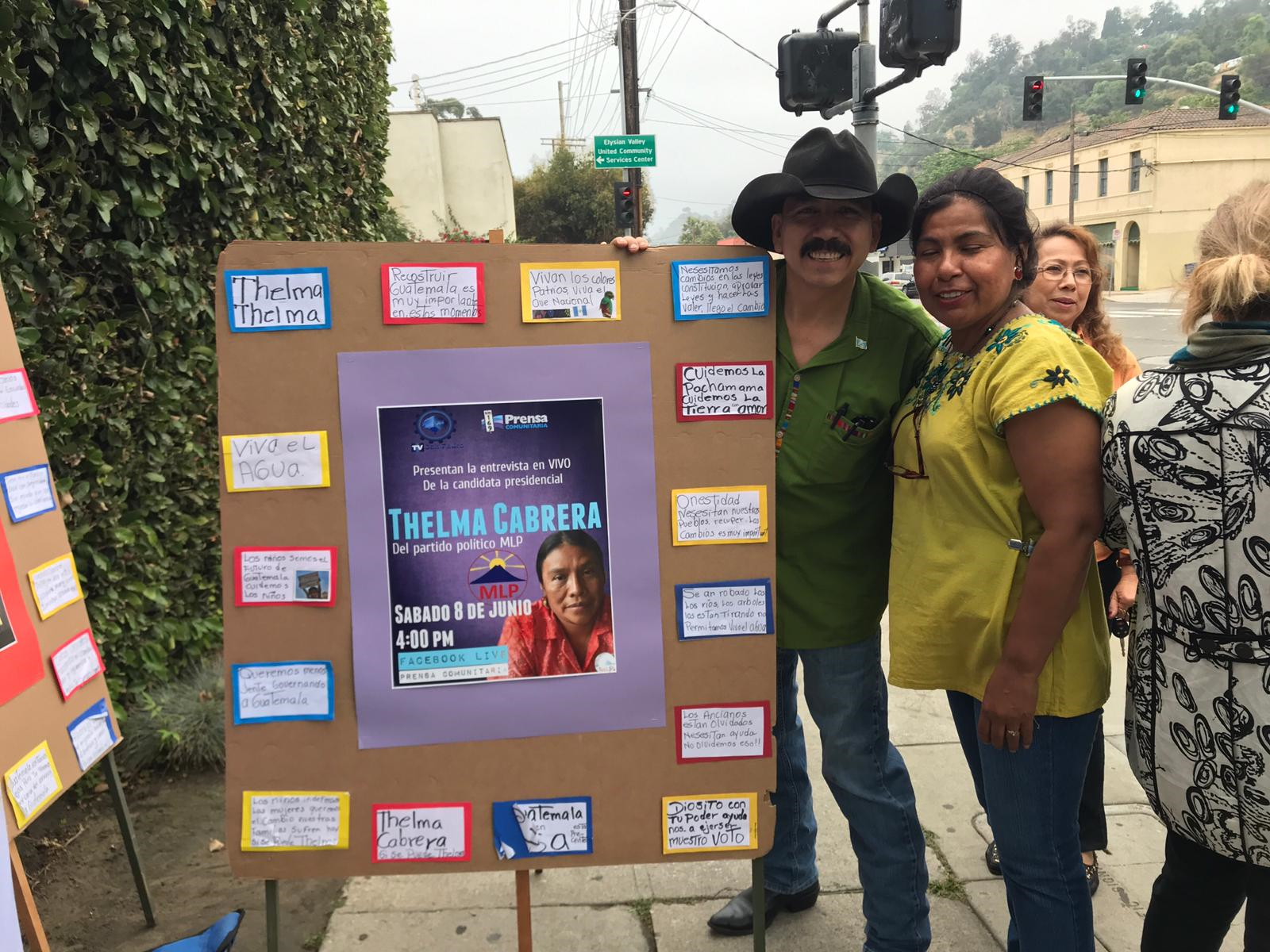Dos guatemaltecos apoyaban con carteles a Thelma Cabrera, en las afueras del consulado de Guatemala en Los Ángeles. (Foto Prensa Libre: Marco López)