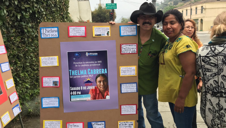 Dos guatemaltecos apoyaban con carteles a Thelma Cabrera, en las afueras del consulado de Guatemala en Los Ángeles. (Foto Prensa Libre: Marco López)