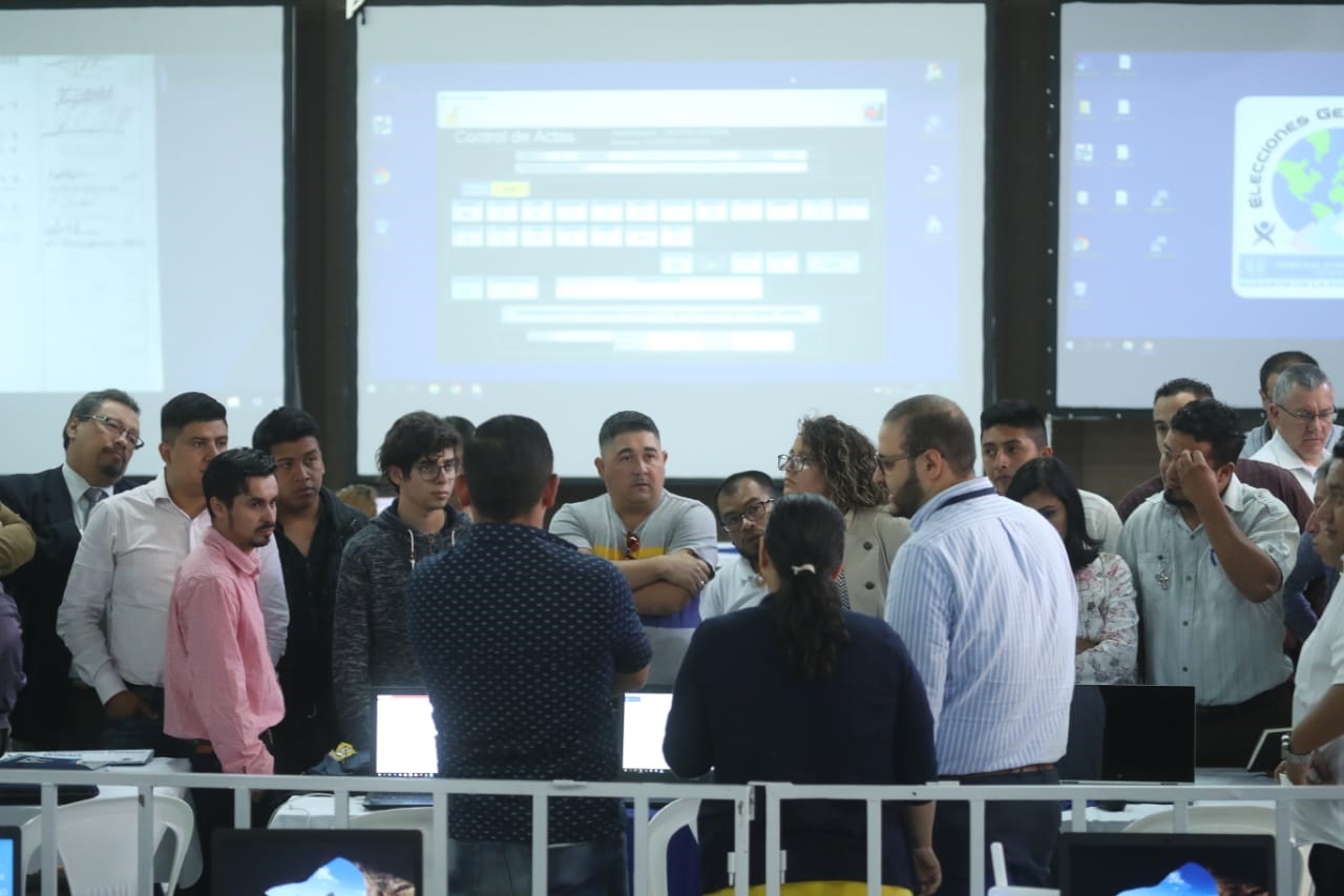 Fiscales de partidos políticos se reúnen en el salón donde se lleva a cabo la revisión de las actas. (Foto Prensa Libre: Esbin García).