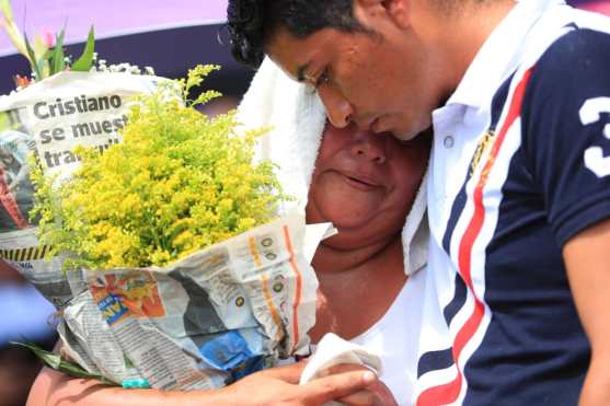 Un joven consuela a su mamá quien llora al recordar a su familia y su antigua casa.  Foto Prensa Libre: Carlos Hernández