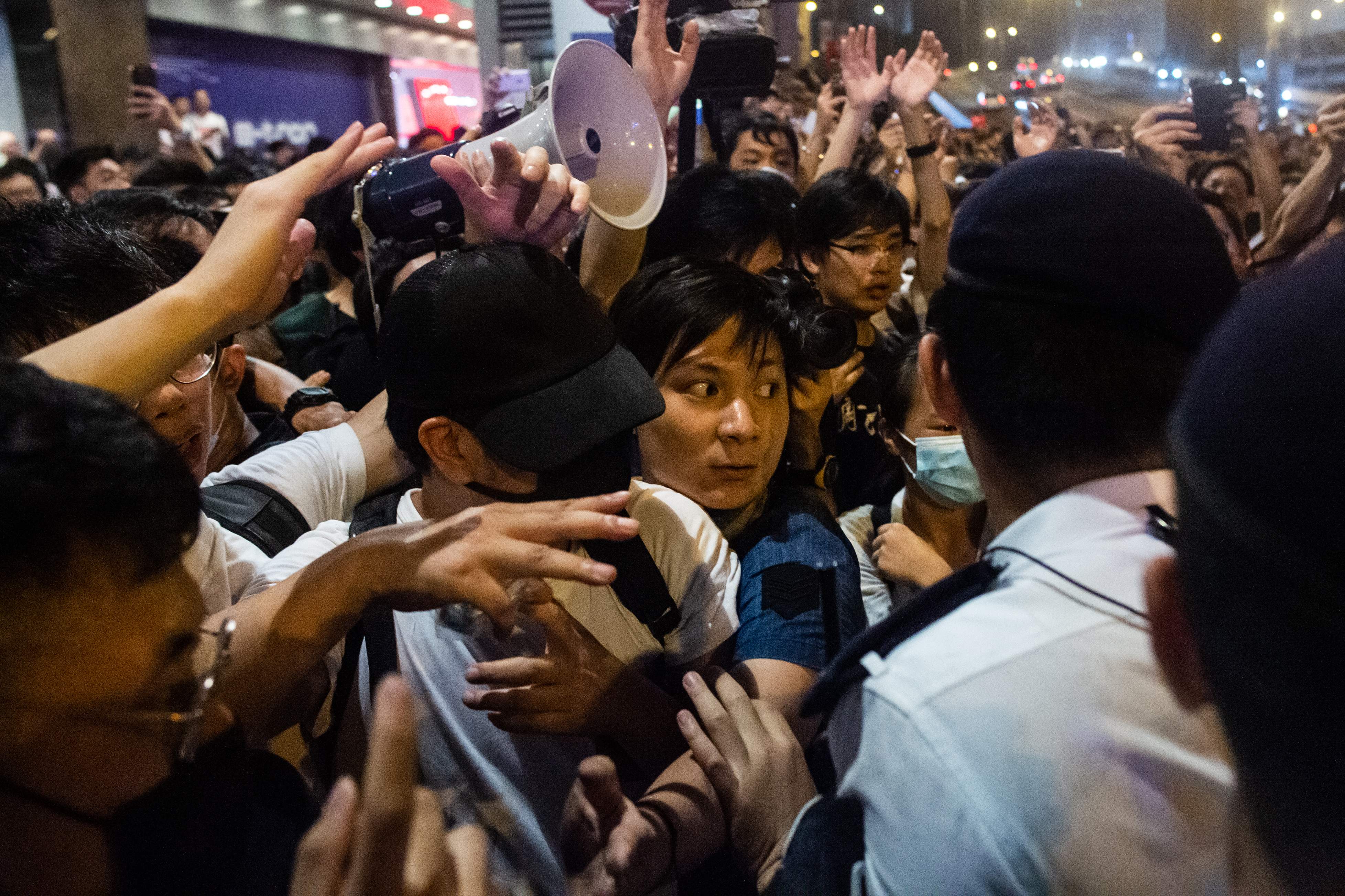 El activista independentista Wayne Chan (al centro) reacciona con los organizadores de la protesta durante un mitin contra una controvertida propuesta de ley de extradición en Hong Kong. (Foto Prensa Libre: AFP)