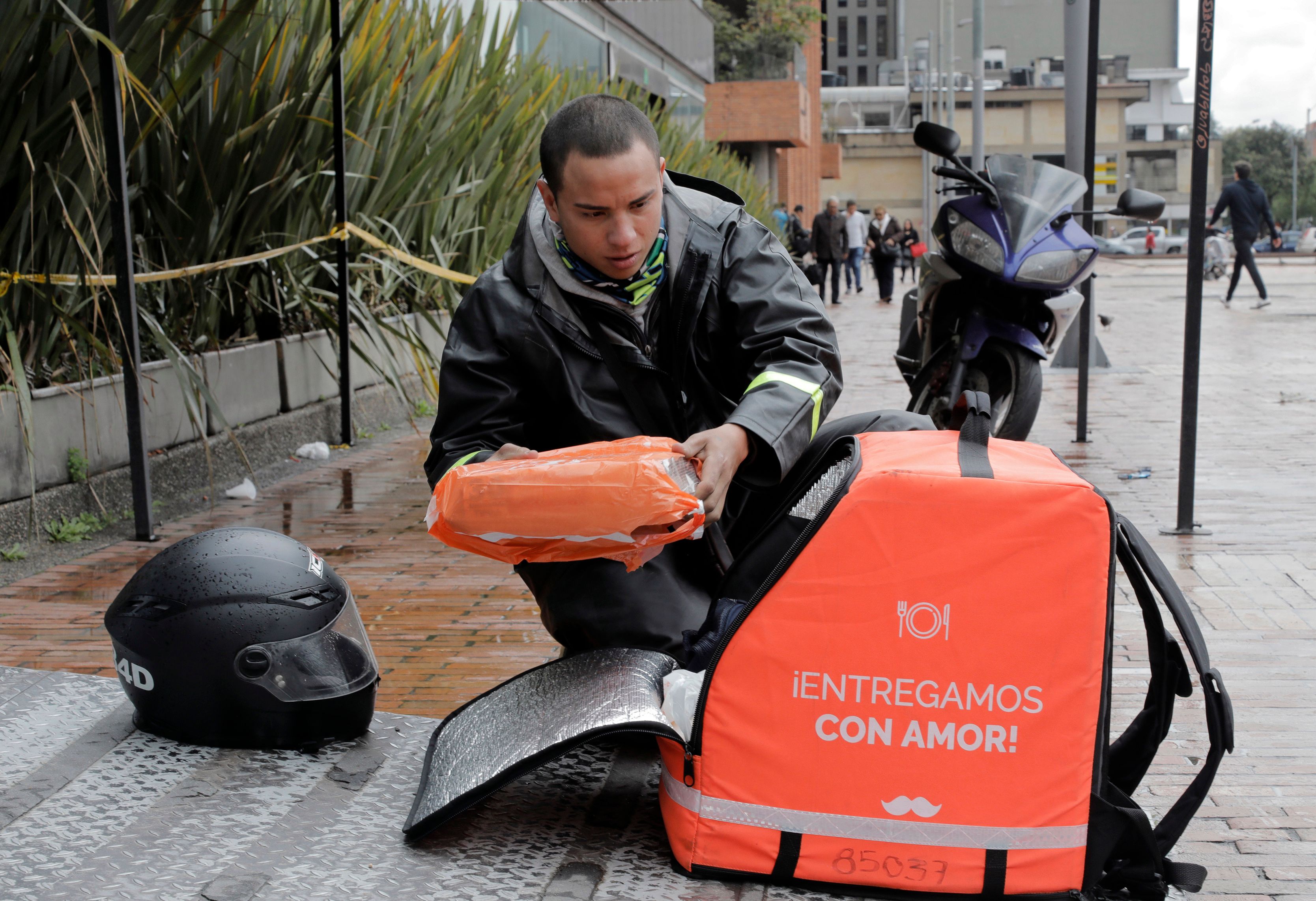 Un mensajero en bicicleta que trabaja para la empresa colombiana de entrega en línea "Rappi", organiza un pedido en Bogotá,. (Foto Prensa Libre: AFP)